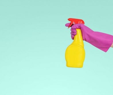 Spray cleaner held by person wearing rubber glove